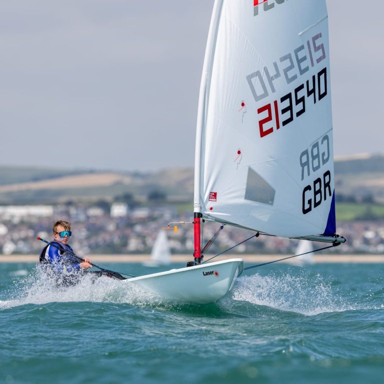 An ILCA 6 sailor racing upwind in a breeze