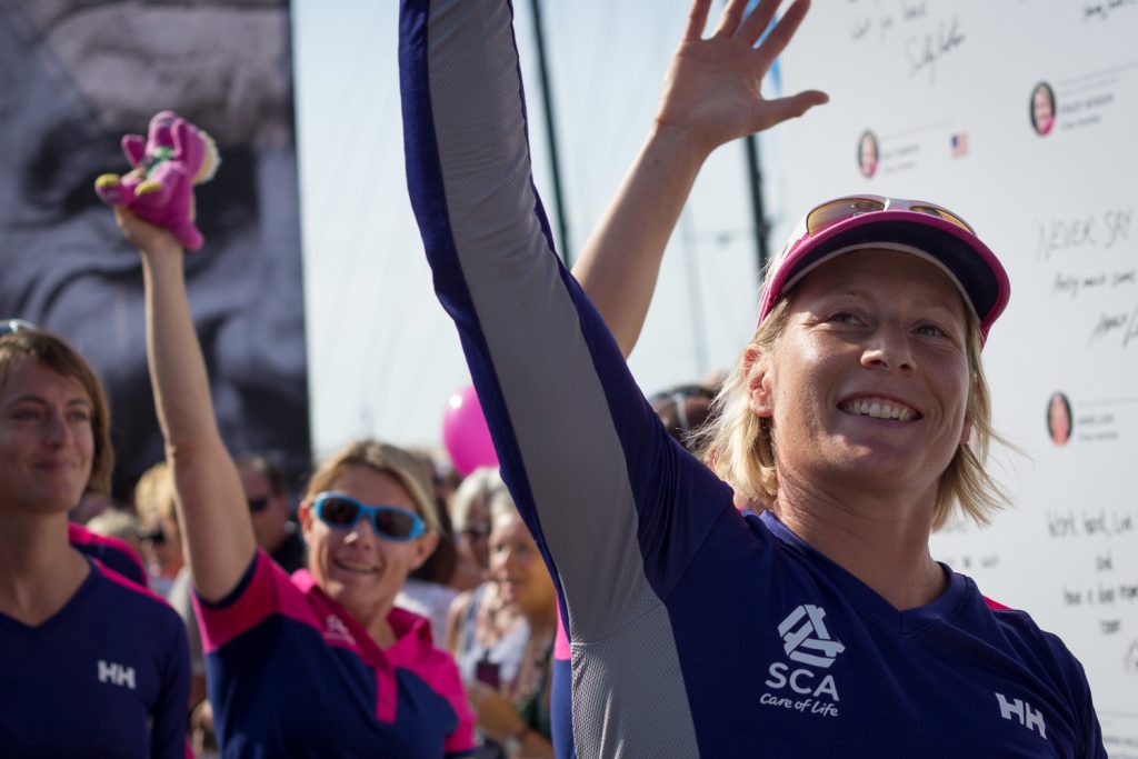 An offshore racing crew member celebrating at the dock